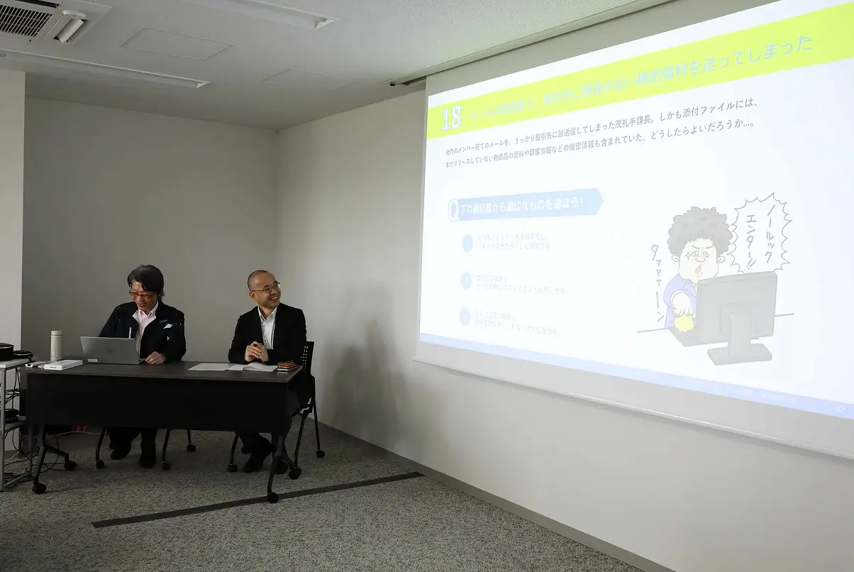 セキュリティクイズをスクリーンに投影した研修の様子